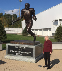 Barbara Giacino poses alongside a statue of her former classmate, football great Jim Brown.